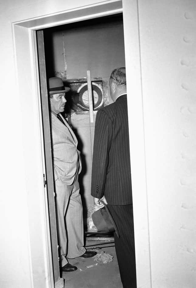 Grover Whalen, left, President of the New York World’s Fair, stands  inside looking at the room of the British Pavilion on  July 4, 1940, where a time bomb was found.