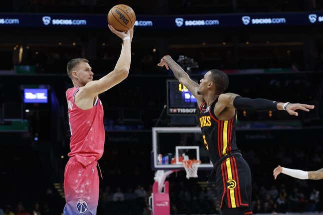 Mar 8, 2023; Washington, District of Columbia, USA; Washington Wizards center Kristaps Porzingis (6) shoots the ball as Atlanta Hawks guard Dejounte Murray (5) defends in the fourth quarter at Capital One Arena.