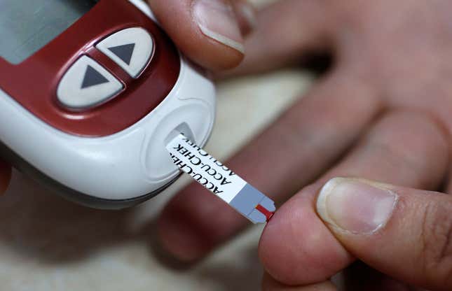 A fingerstick test with a blood glucose monitor, which requires a small drop of blood and a disposable test strip.