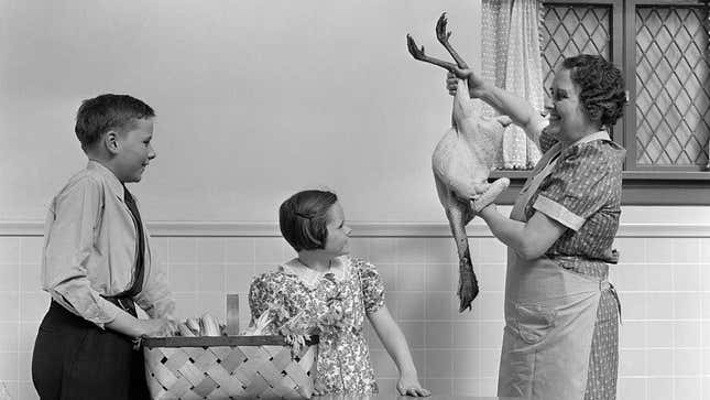 1940s mother proudly holds up plucked turkey to show children