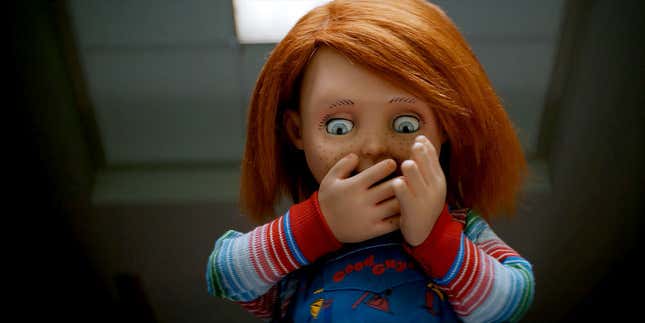 The Chucky doll from Child's Play holds his hands over his mouth in a scene from his TV series.