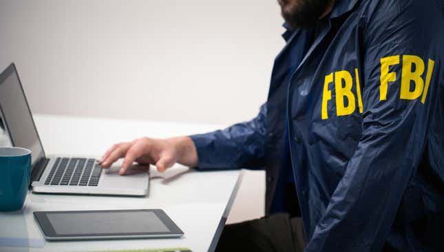 stock image of person on laptop wearing FBI jacket