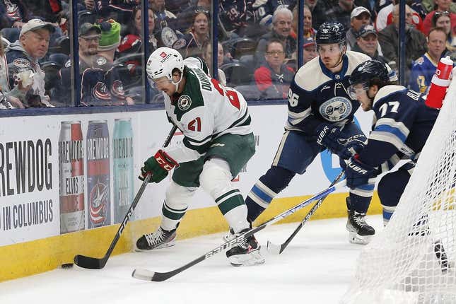 Feb 23, 2023; Columbus, Ohio, USA; Minnesota Wild right wing Brandon Duhaime (21) battles for the puck against Columbus Blue Jackets defenseman Nick Blankenburg (77) during the first period at Nationwide Arena.