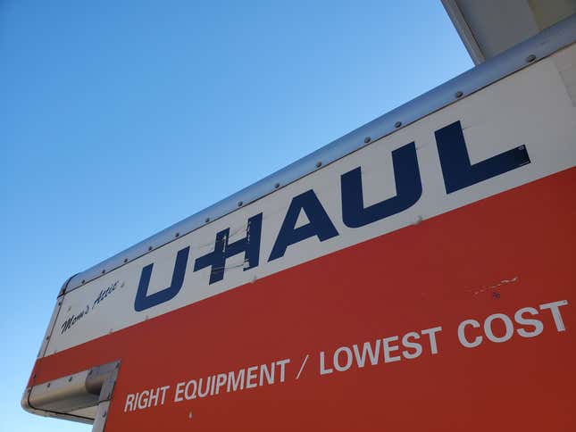 A Uhaul truck logo against a blue sky.