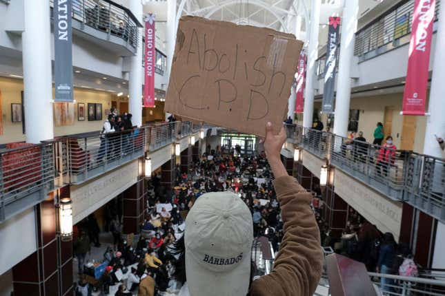 A person holds up a sign as Ohio State University students stage a sit-in at the Ohio Union building on campus in Columbus, Ohio, on April 21, 2021, to protest the killing of MaKhia Bryant, 16, by the Columbus Police Department.