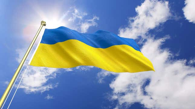 The Ukrainian flag against a blue sky with fluffy clouds.
