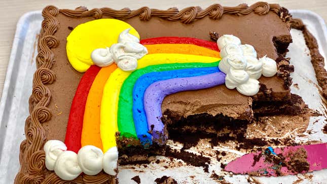 Grocery store chocolate sheet cake with frosted rainbow, half-eaten