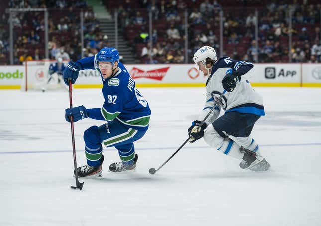Oct 3, 2021; Vancouver, British Columbia, CAN;  Winnipeg Jets defenseman Declan Chisholm (47) checks Vancouver Canucks forward Vasily Podkolzin (92) in the second period at Rogers Arena.