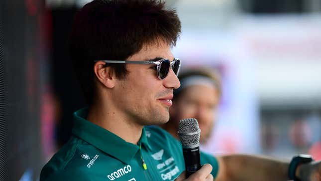 A photo of Lance Stroll speaking into a microphone. 