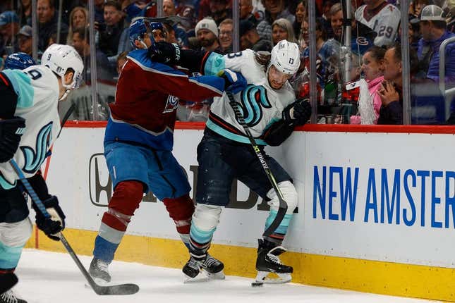 Apr 20, 2023; Denver, Colorado, USA; Seattle Kraken left wing Brandon Tanev (13) and Colorado Avalanche defenseman Erik Johnson (6) battle for the puck in the first period in game two of the first round of the 2023 Stanley Cup Playoffs at Ball Arena.