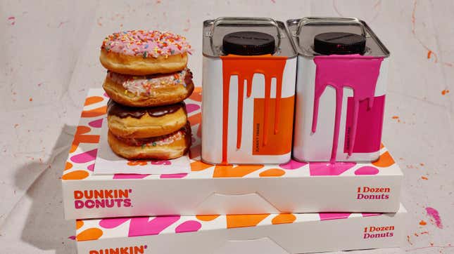 Cans of paint and doughnuts stacked on top of Dunkin' boxes