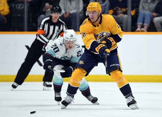 Mar 23, 2023; Nashville, Tennessee, USA; Nashville Predators defenseman Tyson Barrie (22) passes the puck away from pressure by Seattle Kraken right wing Eeli Tolvanen (20) during the first period at Bridgestone Arena.