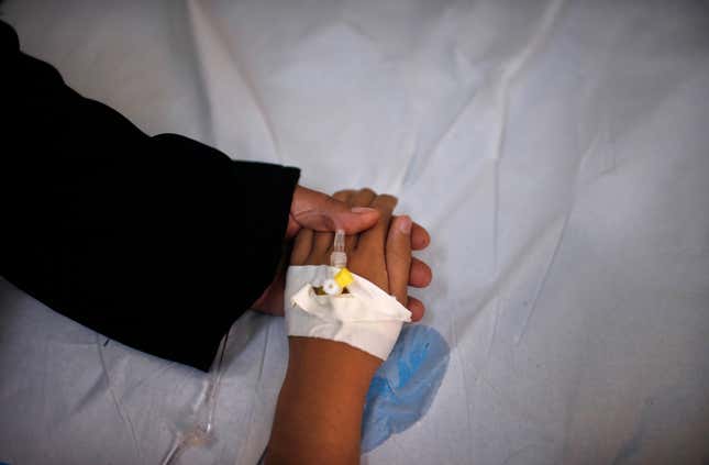 Cancer patient and blind Palestinian girl Aseel al-Haj Ahmed, 9, holds her mother's hand as she receives a regular treatment in a hospital in Gaza City