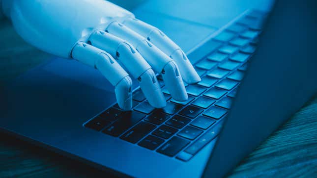 A robot hand uses a laptop keyboard.