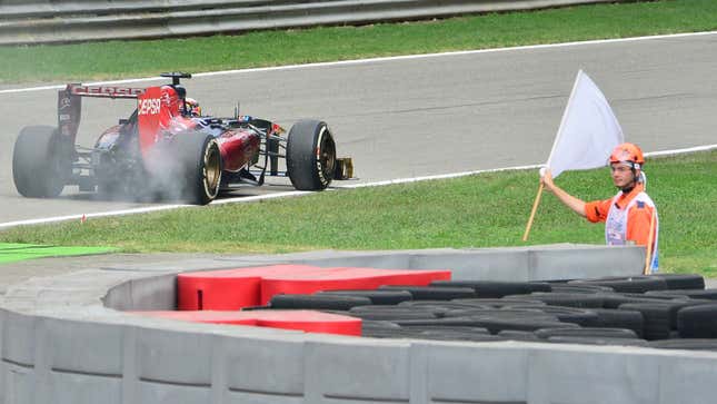 A photo of a white flag being waved in front of Jean Eric Vergne's Toro Rosso F1 car. 