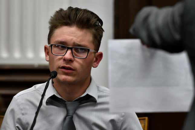 Dominick Black looks at a photograph held by Assistant District Attorney Thomas Binger, where he along with Kyle Rittenhouse and a group of others posed on Aug. 25, 2020, during Kyle Rittenhouse’s trial at the Kenosha County Courthouse in Kenosha, Wis, on Tuesday, Nov. 2, 2021. Rittenhouse was acquitted of killing two people and wounding a third during a protest over police brutality in Kenosha.