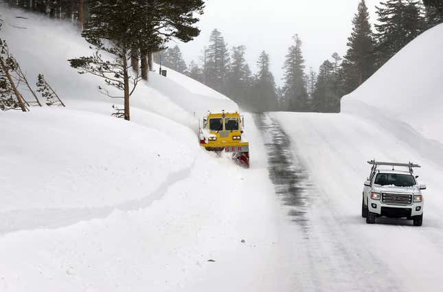 A machine clears snow from a road leading to Mammoth Mountain in the Sierra Nevada mountains, on March 12, 2023 in Mammoth Lakes, California. 
