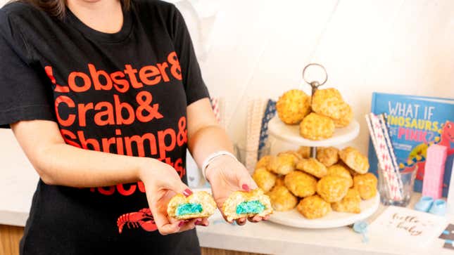 Pregnant woman in Red Lobster t-shirt pulls apart Cheddar Bay biscuits with blue filling