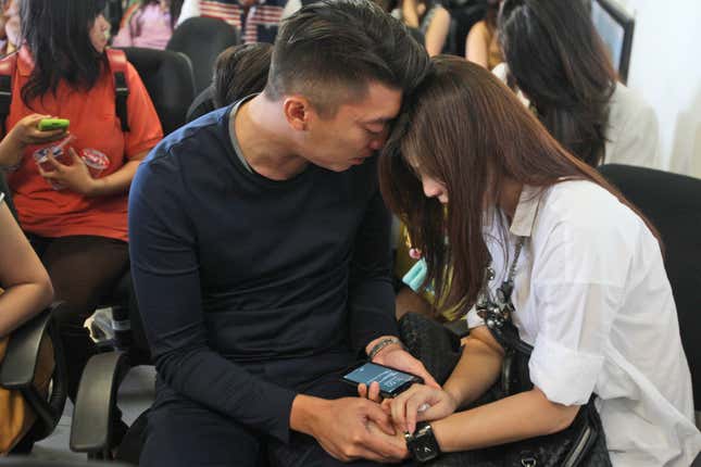 Relatives of the passengers of AirAsia flight QZ8501 comfort each other at Juanda International Airport in Surabaya, East Java, Indonesia.