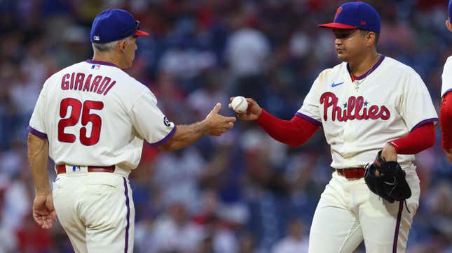 Pitcher Mauricio Llovera of the Philadelphia Phillies hands the ball to manager Joe Girardi after surrendering three consecutive home runs during the ninth inning of a game against the New York Mets