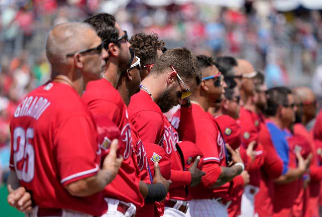 Joe Girardi and the Phillies stand for the anthem at Spring Training.