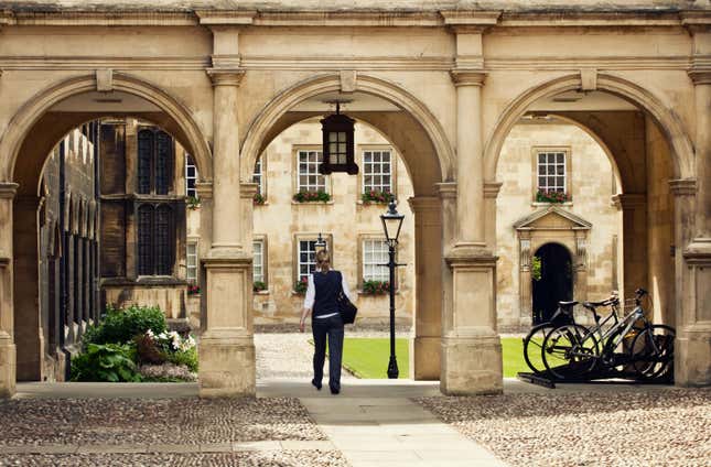 A student passing through a college campus in Cambridge Universitiy, UK.
