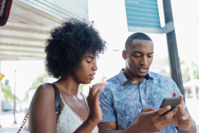 Black couple looking at phone 