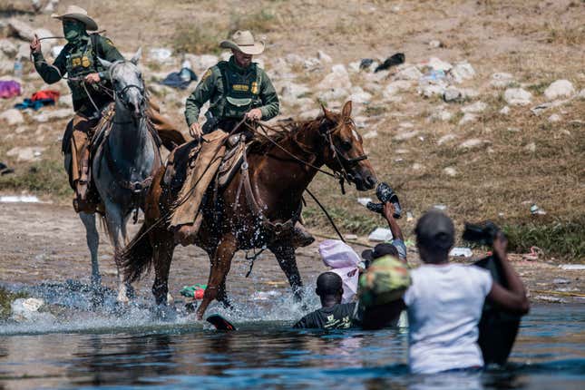 Mounted U.S. Border Patrol agents attempt to contain migrants as they cross the Rio Grande from Ciudad Acuña, Mexico, into Del Rio, Texas, Sept. 19, 2021.