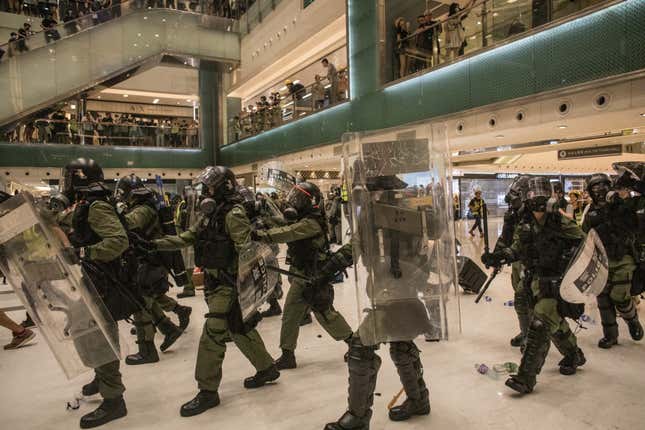 Riot police chase protesters through a shopping mall on July 14, 2019 in Hong Kong.