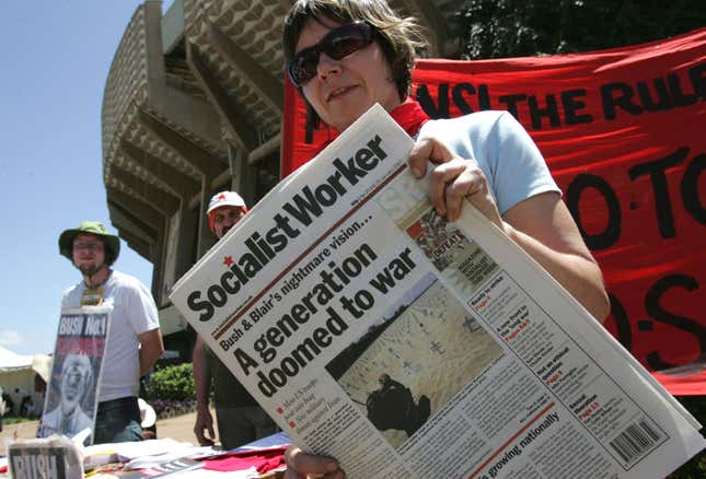 Delegates hold posters and a newspaper against the Iraq war, at the World Social Forum in Nairobi Monday, Jan. 22, 2007.The World Social Forum was first held in Brazil in 2001 and coincides each year with the market-friendly World Economic Forum of political and business leaders in Davos, Switzerland.
