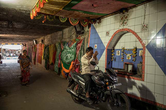 A man stops to pay respects at the Pir Baba shrine under the Narkeldanga railways tracks.