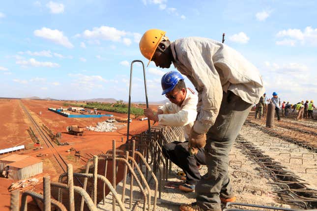 A Chinese engineer and a local construction worker in Kenya.