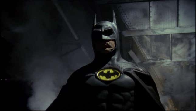 Michael Keaton wears his black cowl and cape with the yellow and black Batman logo on his chest  in Tim Burton's 1989 Batman movie.