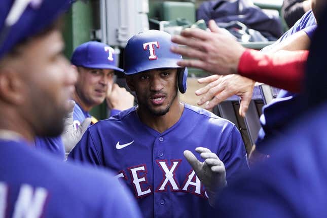 Apr 9, 2023; Chicago, Illinois, USA; Texas Rangers center fielder Bubba Thompson (8) is greeted in the dugout after scoring against the Chicago Cubs during the sixth inning at Wrigley Field.
