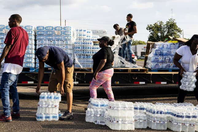 JACKSON, MS - AUGUST 31: Cases of bottled water are handed out at a Mississippi Rapid Response Coalition distribution site on August 31, 2022, in Jackson, Mississippi. Jackson is experiencing a third day without reliable water service after river flooding caused the main treatment facility to fail. Late Tuesday night, President Joe Biden declared an emergency amid the crisis.