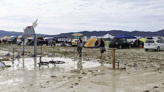 Burners treading through the muck following a heavy downpour at the Burning Man festival in Black Rock City, Nevada, September 2, 2023.
