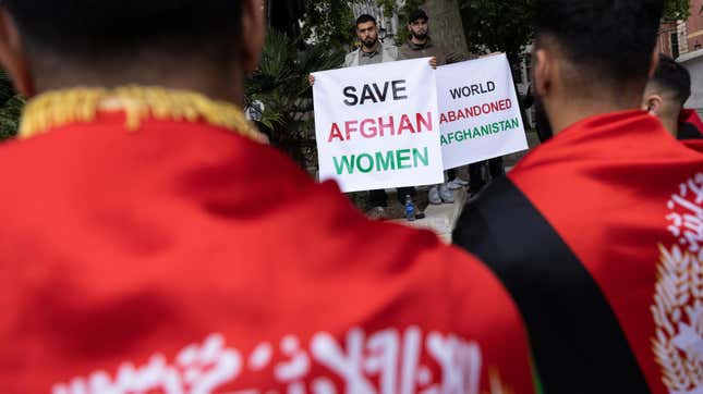 British protestors hold up signs asking the UK government to save Afghan women