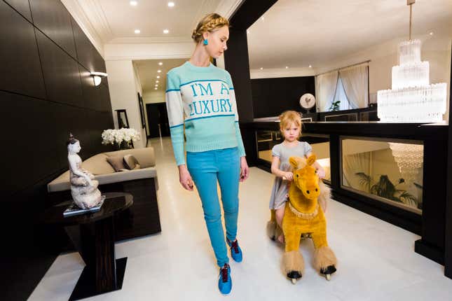 Ilona, a photographer and former model originally from Latvia, in the mezzanine library of her home, which so far contains only copies of a self-published book of her fashion photographs, in Moscow, 2012.