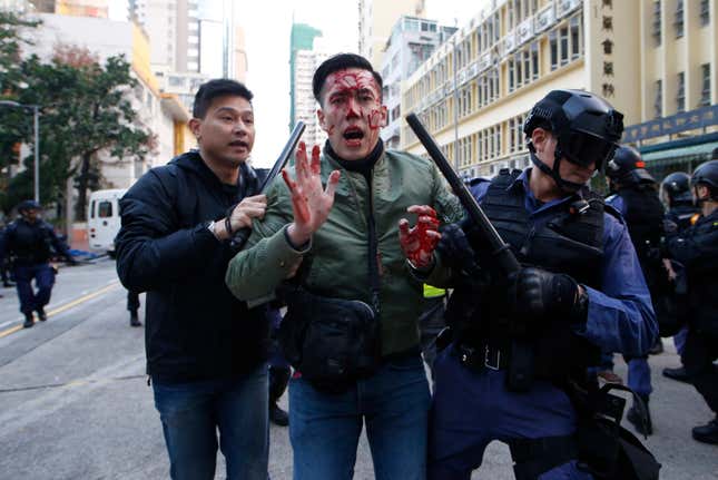 A rioter is taken away by police on a street in Mong Kok.