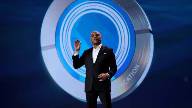 Carnival CEO Arnold Donald holds up the Ocean Medallion wearable for cruise ship passengers, during his 2017 keynote at CES in Las Vegas