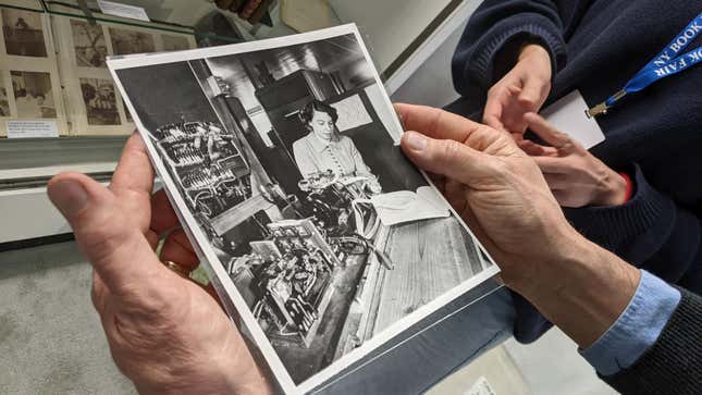 A photo in a person's hands of Jean Hall, an early computer scientist and pioneer into the realm of digital computers, feeds perforated paper into an early computing machine in 1953.