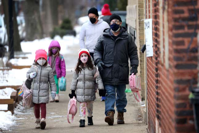 CHICAGO, ILLINOIS - JANUARY 12: Students walk to A. N. Pritzker elementary school on January 12, 2022, in Chicago, Illinois. Students in Chicago public schools are returning to school today after classes were canceled for the past six days as the city sparred with the teacher’s union over COVID-19 safety measures.