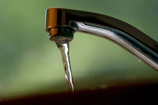 Tap water flows from a faucet. 