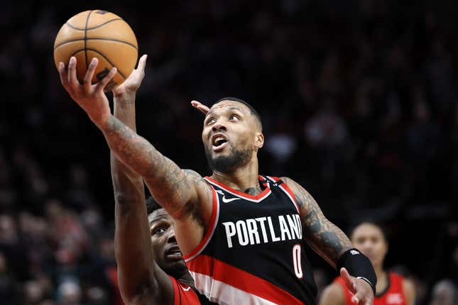 Feb 26, 2023; Portland, Oregon, USA; Portland Trail Blazers point guard Damian Lillard (0) shoots the ball past Houston Rockets small forward Jae'Sean Tate (8, left) during the second half at Moda Center.