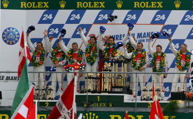 Mike Rockenfeller of Germany celebrates with compatriot Timo Bernhard and Romain Dumas of France the drivers of the #9 Audi Sport North America Audi R15 and their team mates from the second and third placed cars as Audi make a clean sweep after winning the 78th running of the Le Mans 24 hours race at the Circuits des 24 Heures du Mans on June 13, 2010 in Le Mans, France.