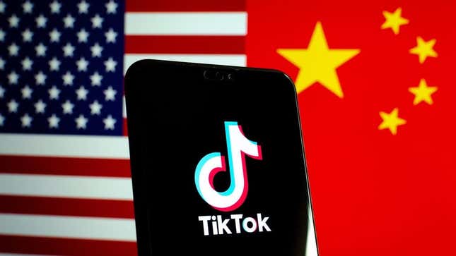The TikTok logo on a phone in front of the American and Chinese flags