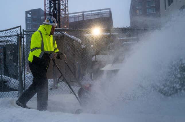 A worker with RJM Construction clears snow from a work site on February 23, 2023 in Minneapolis, Minnesota. 