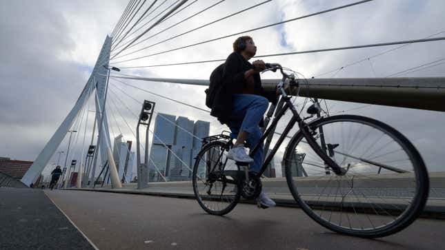 A photo of a person cycling across a bridge in The Netherlands. 