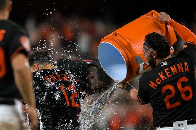 Apr 21, 2023; Baltimore, Maryland, USA;  Baltimore Orioles second baseman Adam Frazier (12)  gets water dumped on him by left fielder Ryan McKenna (26) after defeating against the Detroit Tigers   at Oriole Park at Camden Yards.