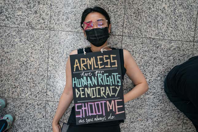 A protester lies on the floor of the arrival hall of Hong Kong International Airport during a demonstration on Aug. 12, 2019.